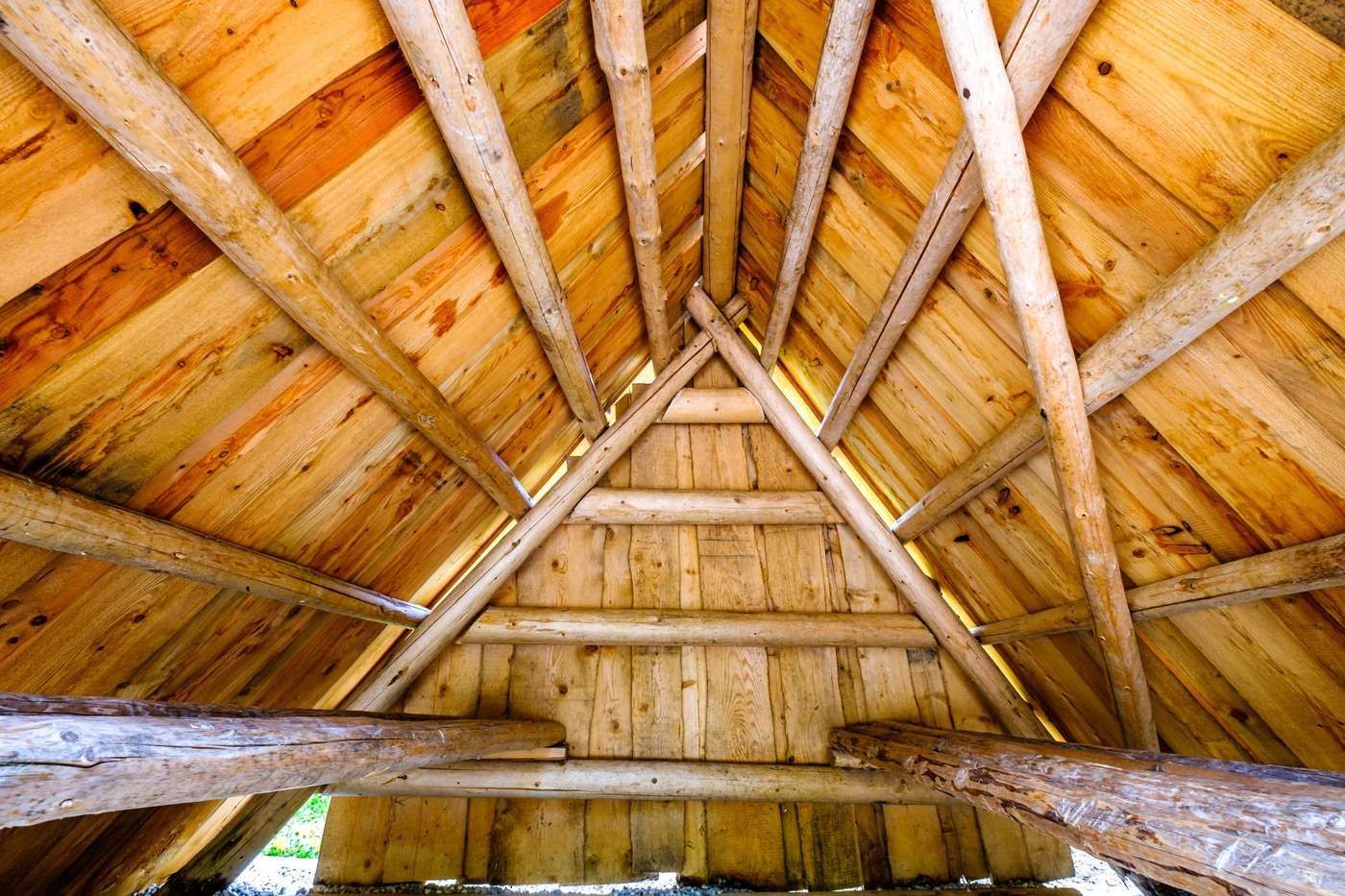 Las cerchas interiores de madera del techo forman un techo triangular con tablones y vigas de tonos cálidos.