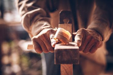 Mies vuolemassa puuta