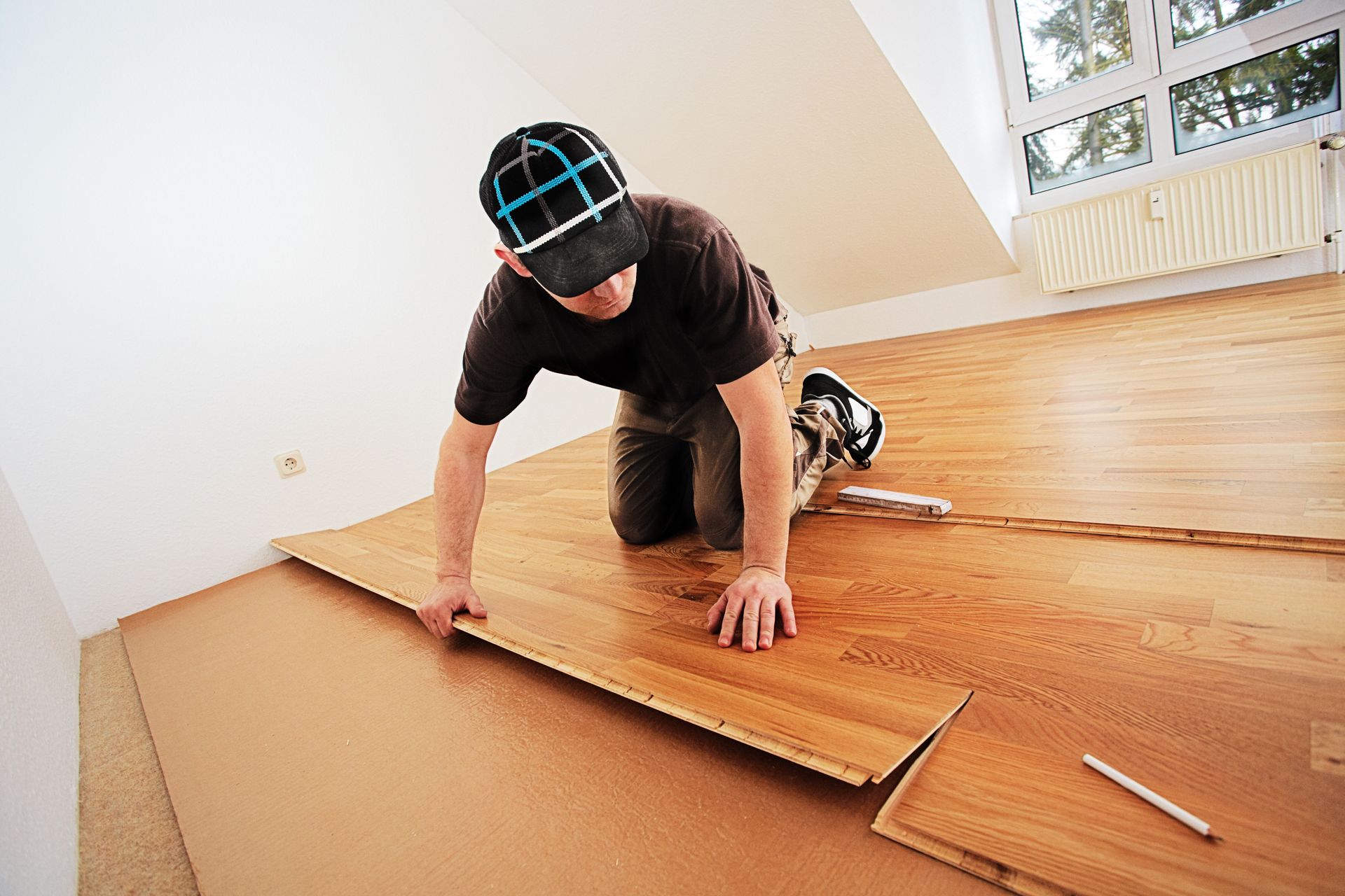 Un homme pose du parquet flottant