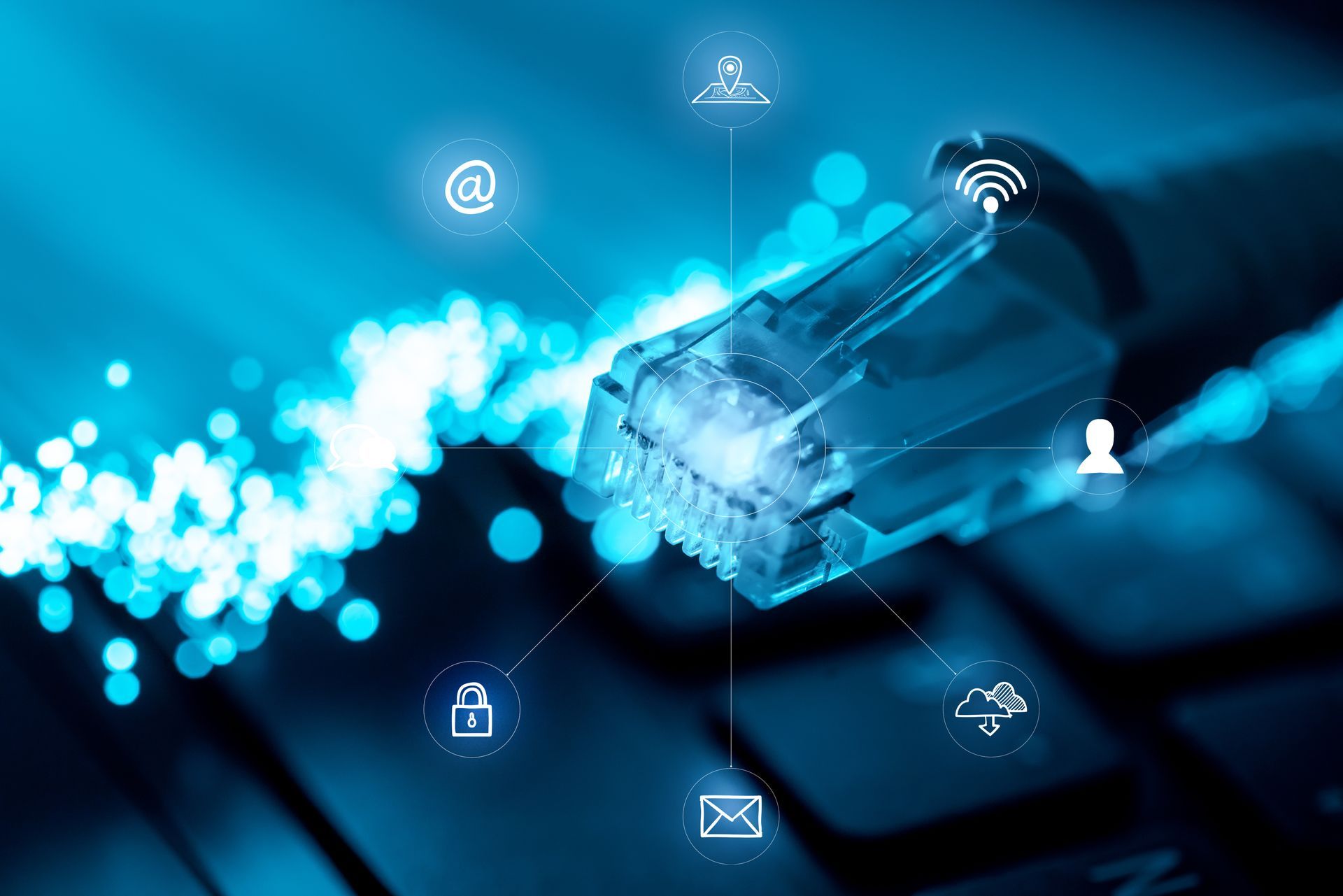 Câble Ethernet branché avec des icônes de données lumineuses, des teintes bleues sur le clavier.