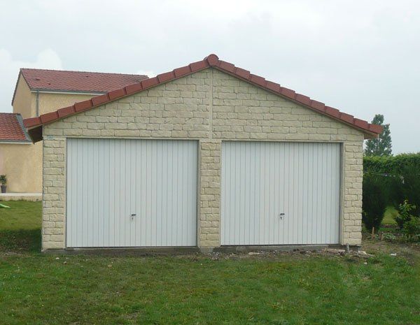 Garage double avec deux grandes portes blanches