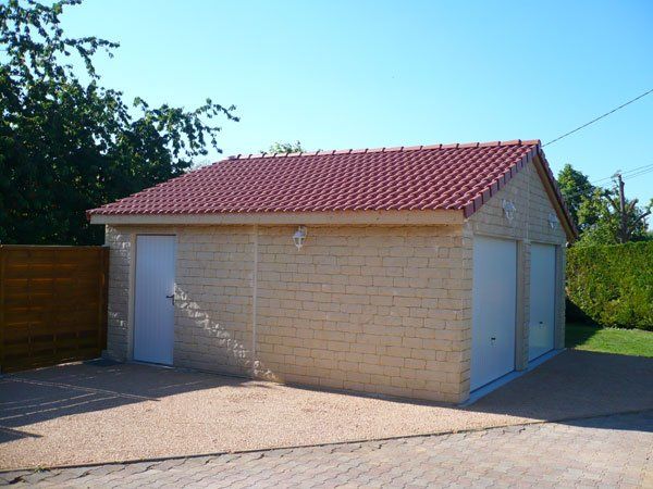 Garage Fedelich avec toit rouge et portes blanches