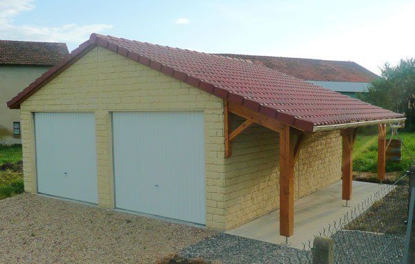 Garage double avec portes blanches et auvent