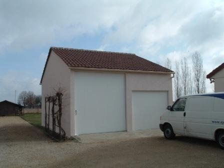 Garage avec portes blanches et un camion