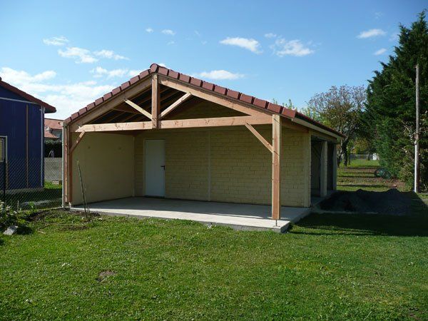 Garage avec auvent et porte blanche