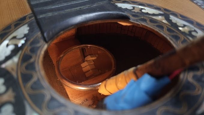 Un primer plano de un objeto de madera con un objeto azul dentro.