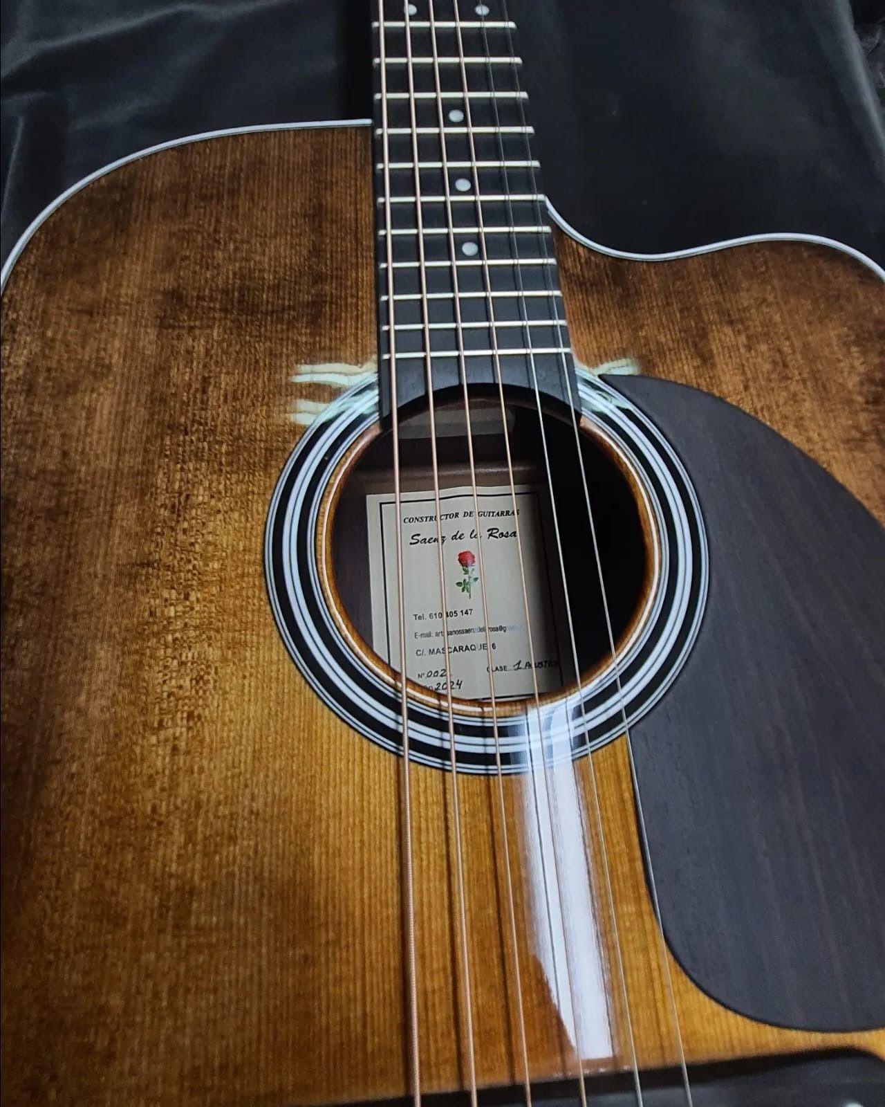 Un primer plano de una guitarra acústica con una etiqueta.