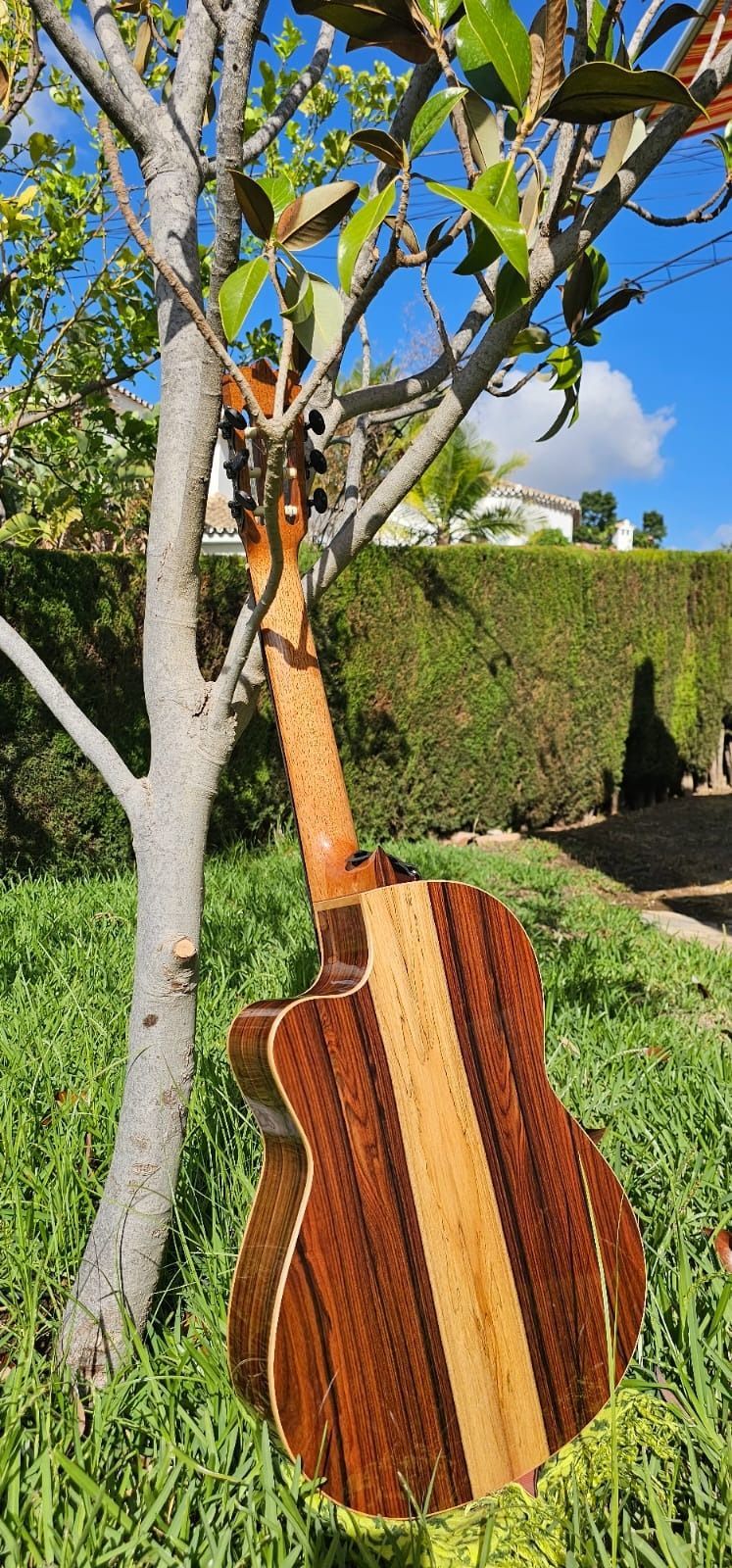 Una guitarra cuelga de un árbol en el césped.