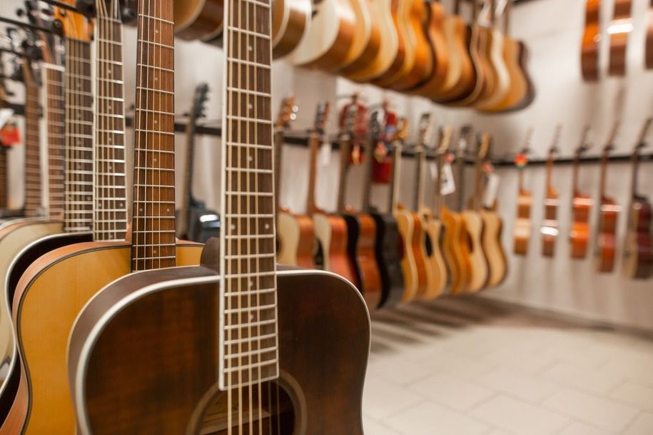 Una fila de guitarras colgadas en la pared de una tienda.