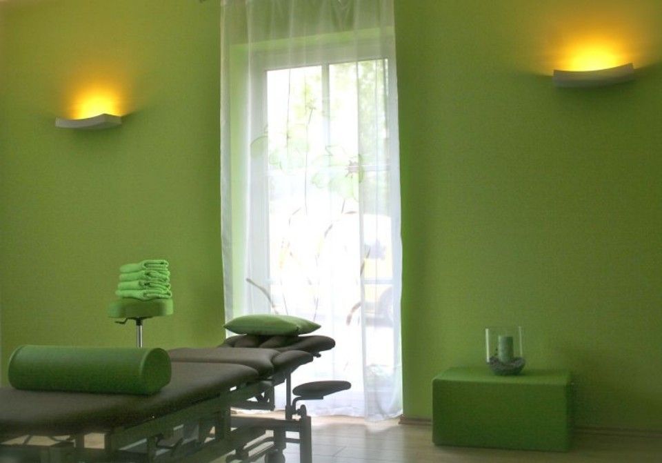 Therapieraum in freundlichem Grün mit Therapieliege