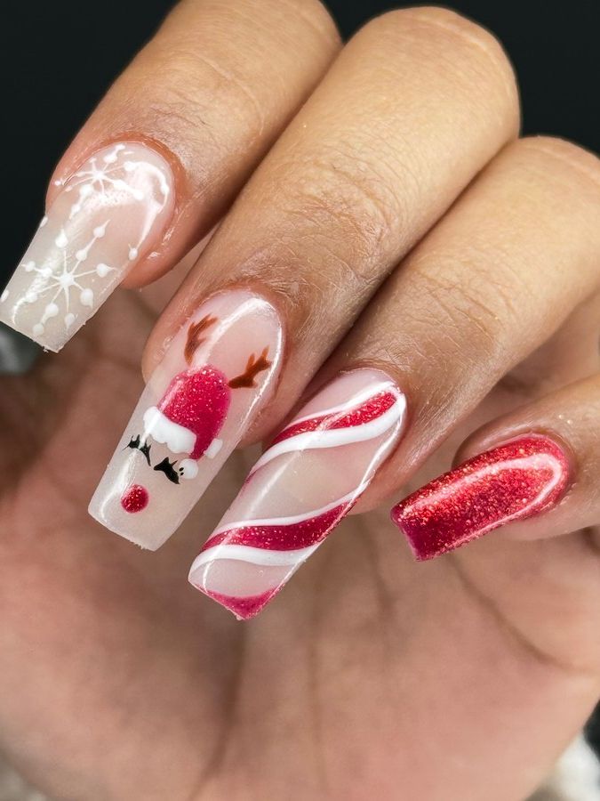 Un primer plano de las uñas de una persona con un diseño de Papá Noel y bastón de caramelo.