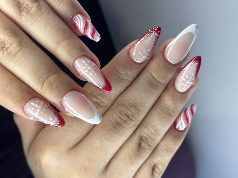 Un primer plano de las uñas de una mujer con un diseño rojo y blanco.