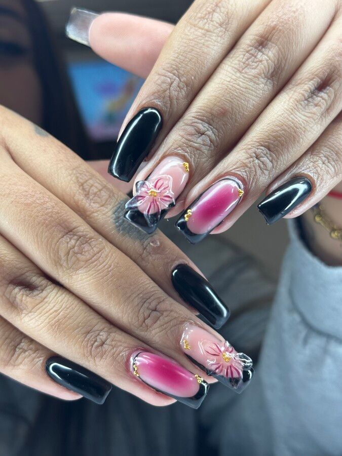 Un primer plano de las uñas de una mujer con un diseño floral.