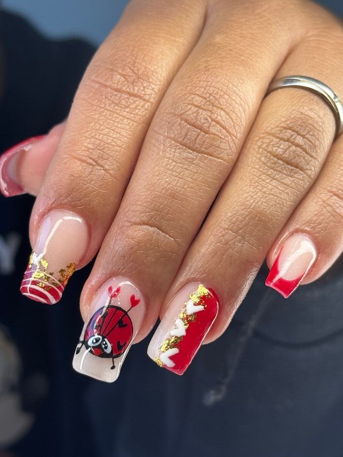 Una mariquita está pintada en las uñas de una mujer.