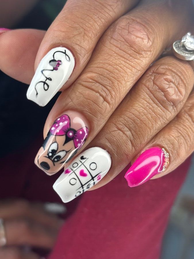 Un primer plano de las uñas de una mujer con un diseño de Minnie Mouse.