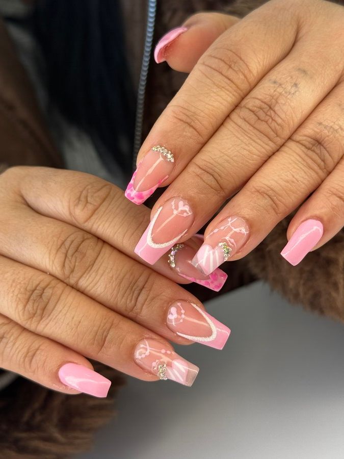 Un primer plano de las manos de una mujer con uñas rosas.