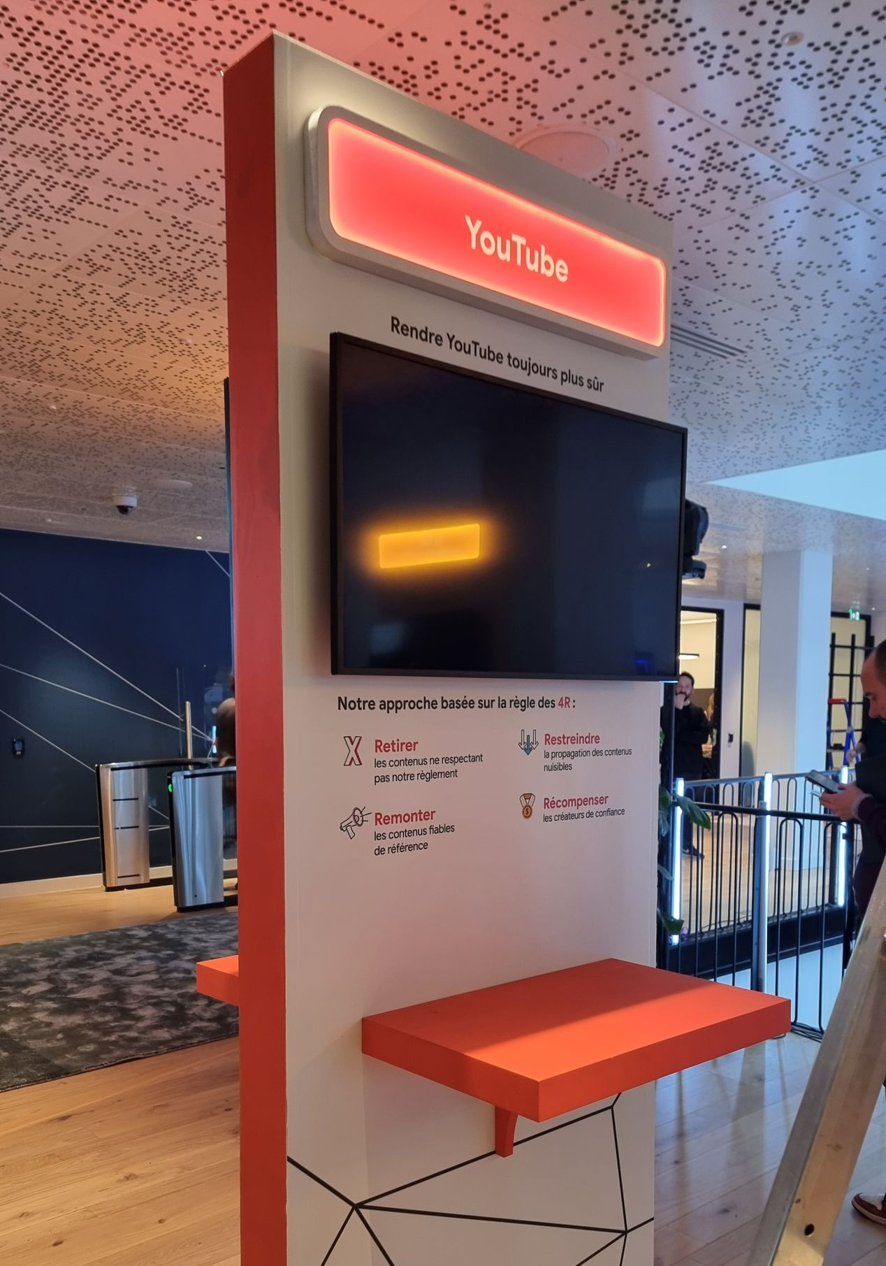 Présentoir YouTube avec écran et touches orange.