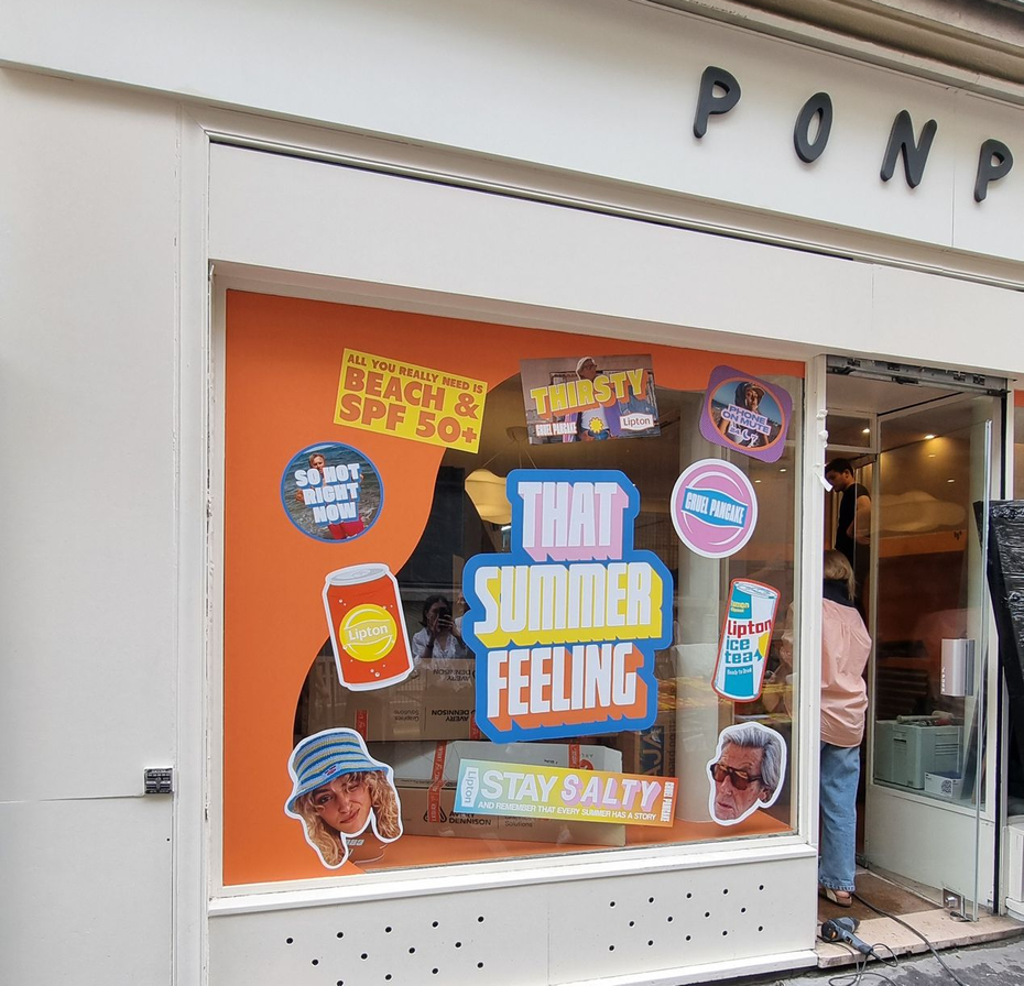 Vitrine avec une décoration sur le thème de l'été, ornée d'autocollants colorés.
