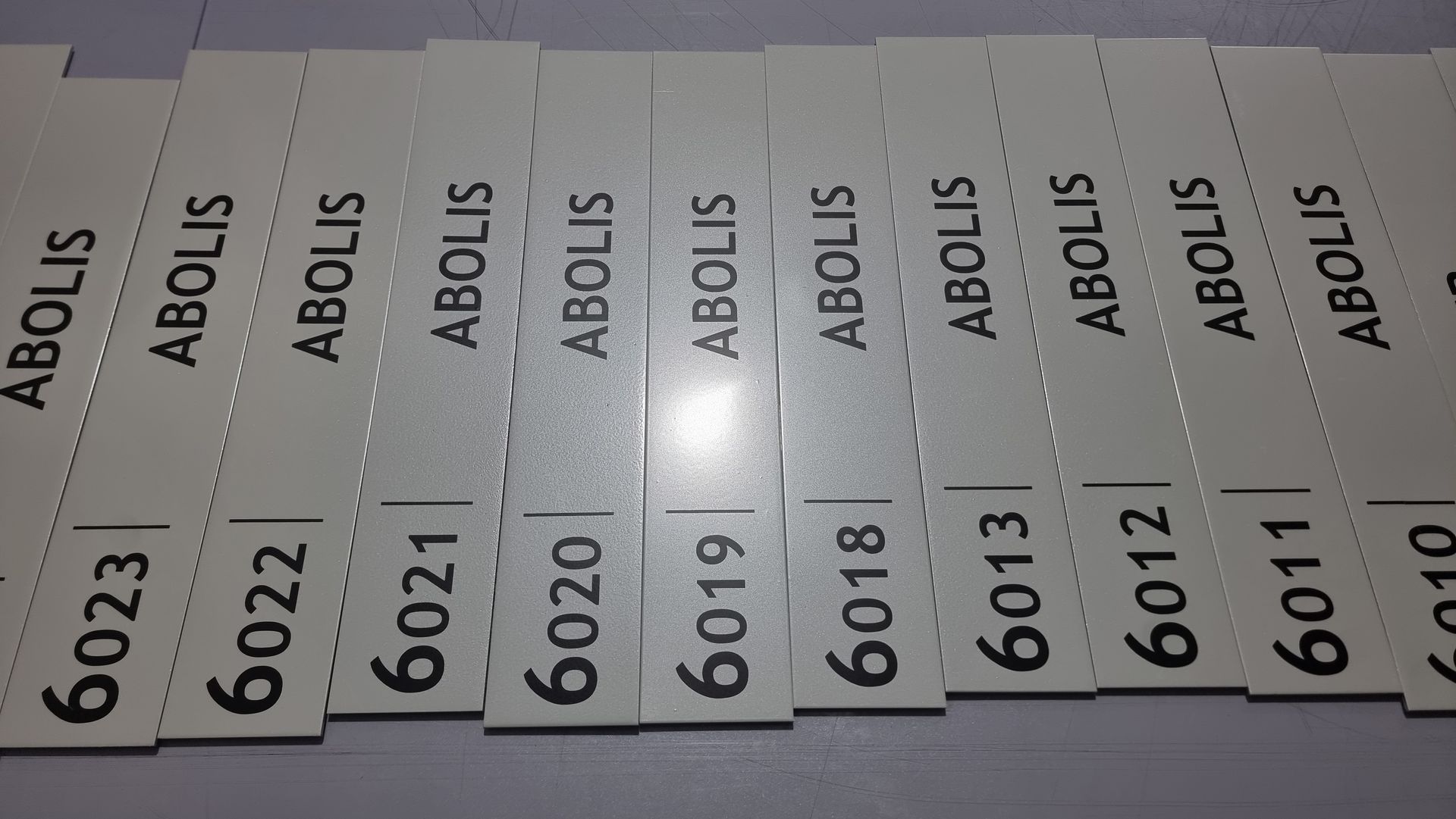 Étiquettes rectangulaires blanches imprimées avec ABOLIS et des numéros séquentiels