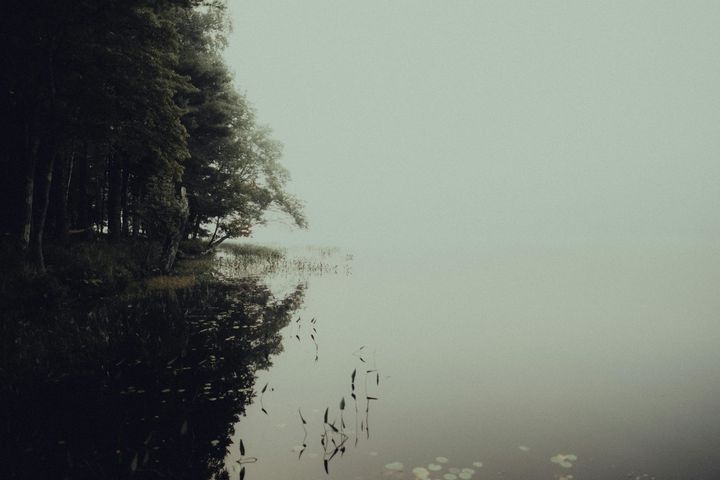 Ein gelber Schutzhelm, ein Massband und eine Wasserwaage liegen auf den Bauplänen.