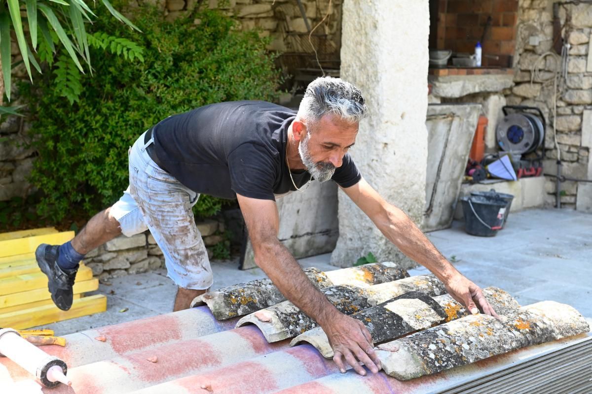 Mise en place des anciennes tuiles sur la nouvelle charpente afin de conserver l'aspect vieilli