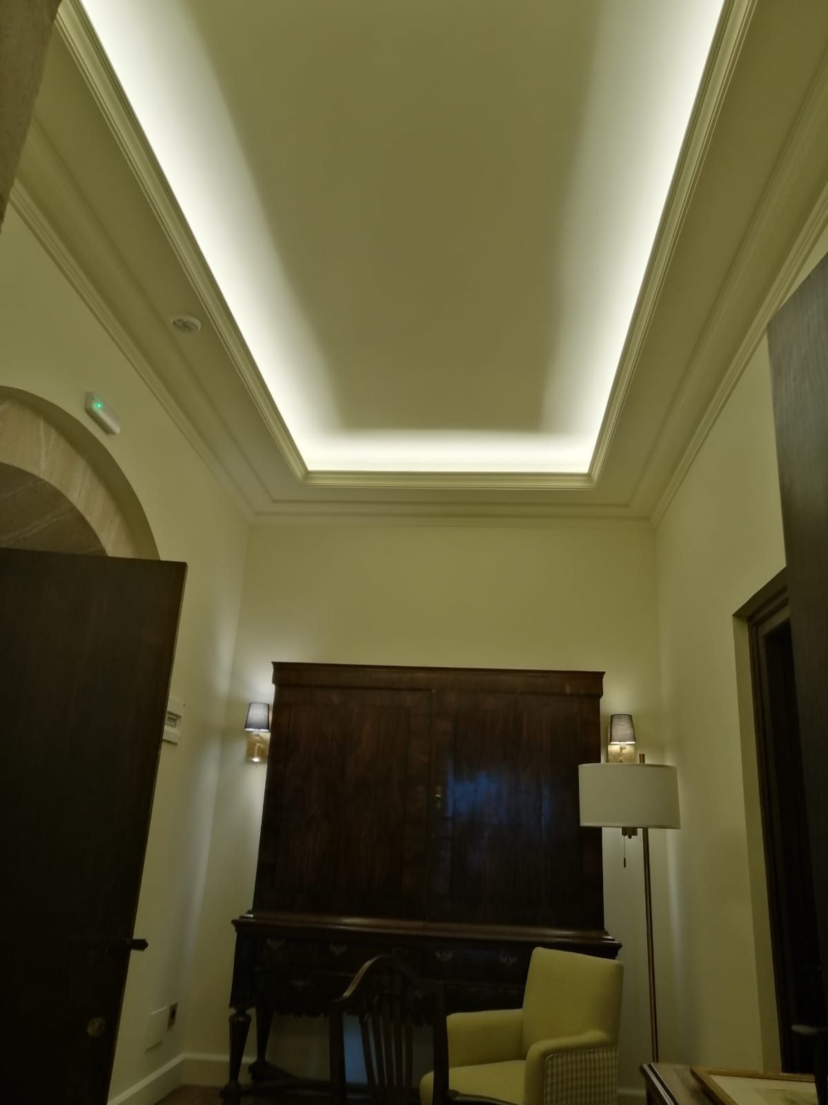 Una habitación con un piano, una silla y una lámpara.