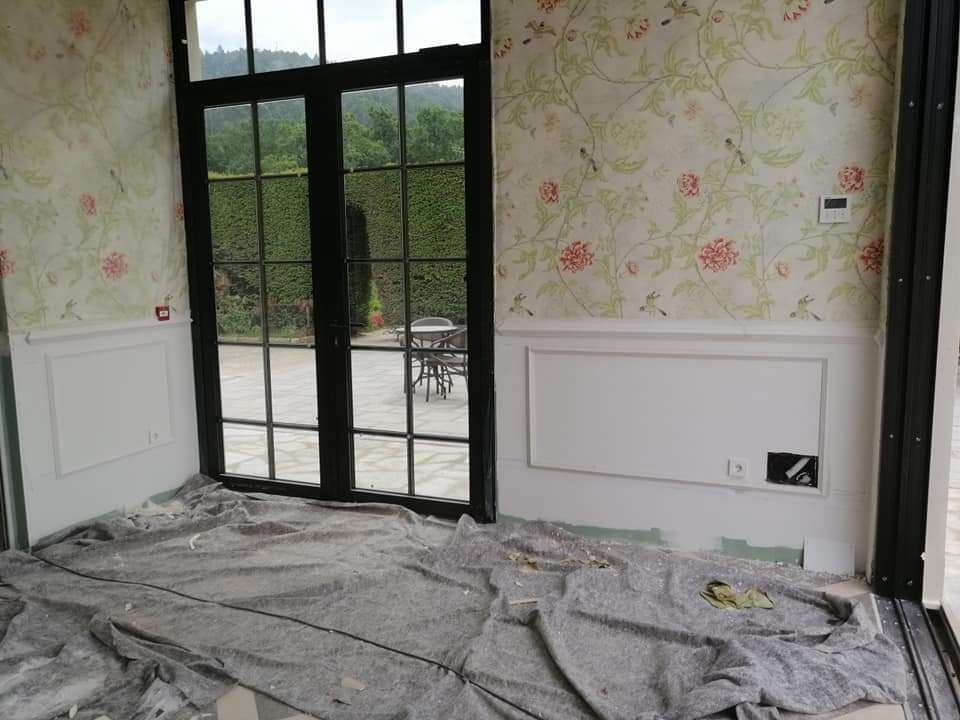 Una habitación con muchas ventanas y una manta en el suelo.