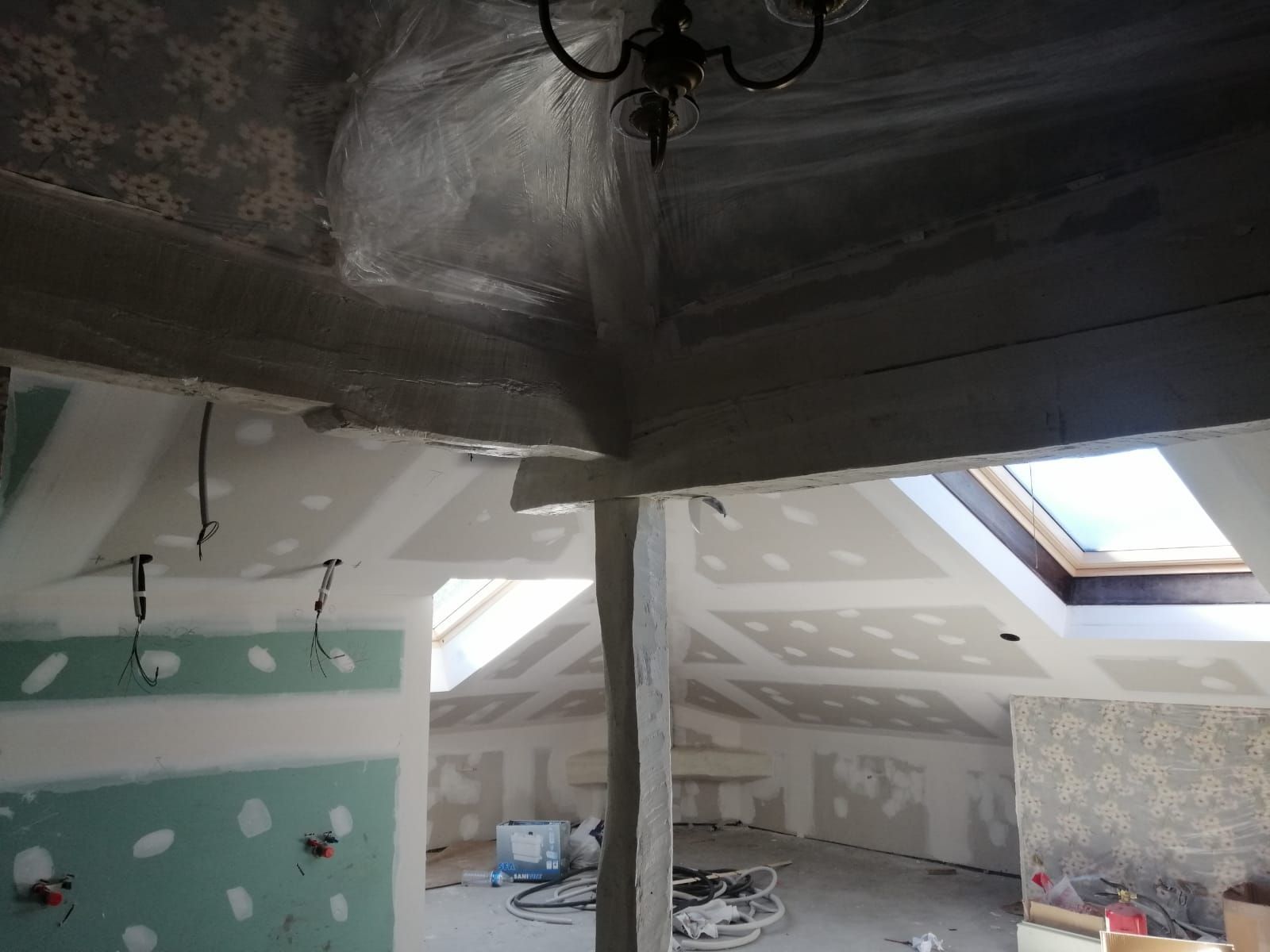 Un ático con una claraboya y una lámpara de araña colgando del techo.