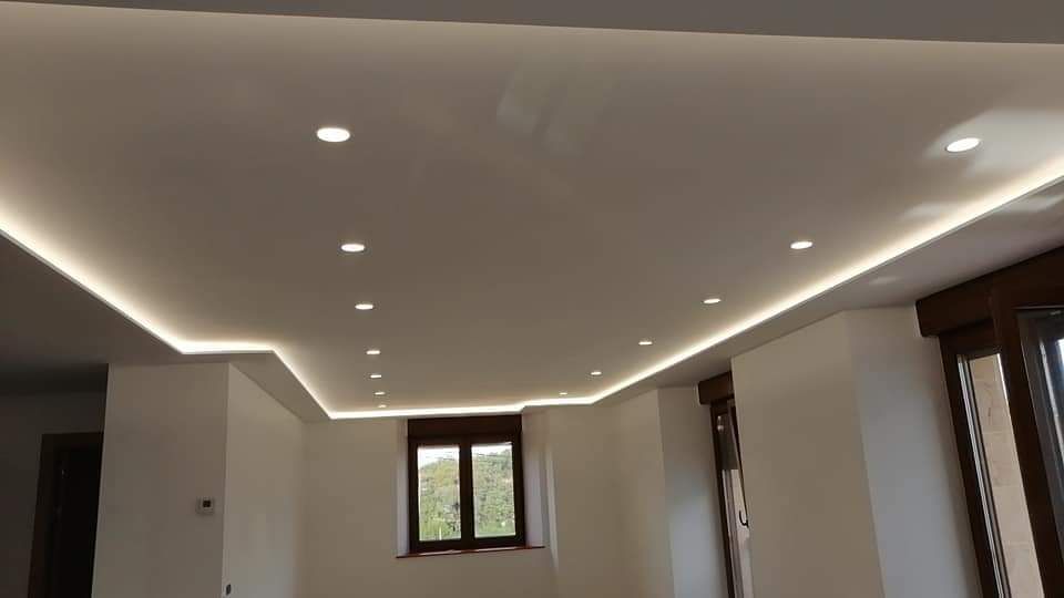 Una sala de estar con techo blanco y una ventana.