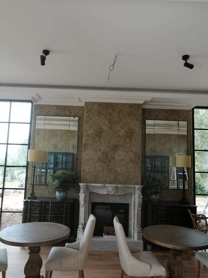 Una sala de estar con chimenea, mesas y sillas.