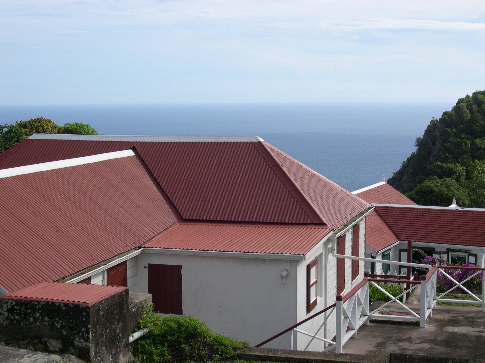 Red-roofed seaside buildings overlooking the ocean under a clear sky