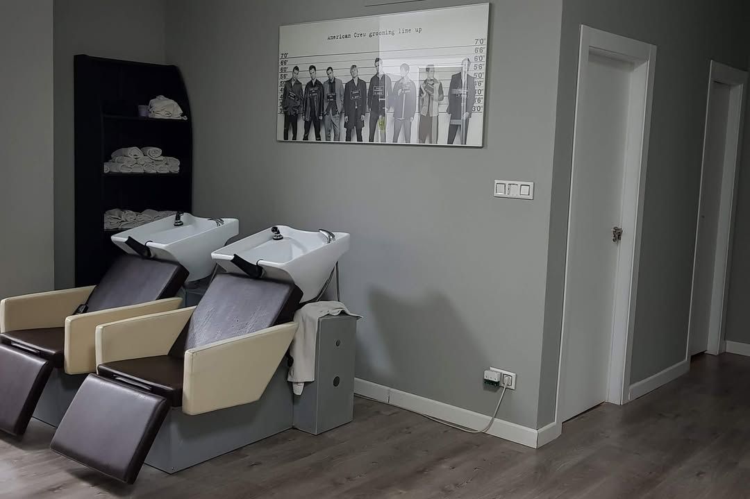 Dos estaciones de lavado de cabello con lavabos y sillones reclinables en un salón 