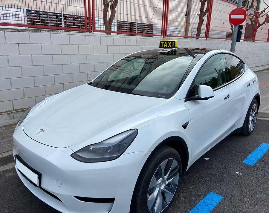 Un Tesla modelo Y blanco está estacionado en un estacionamiento.