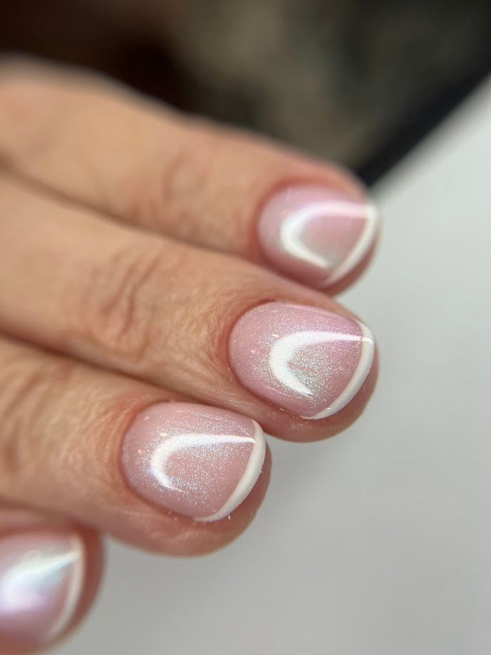 Ongles courts, rose clair, avec des motifs blancs incurvés.