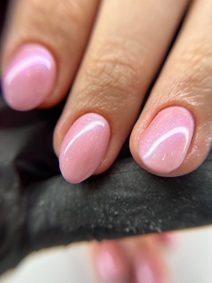Ongles roses, de forme ovale, avec une finition nacrée.