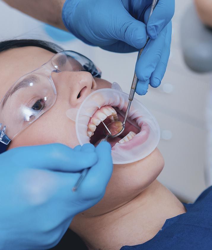Una mujer está siendo examinada por un dentista.