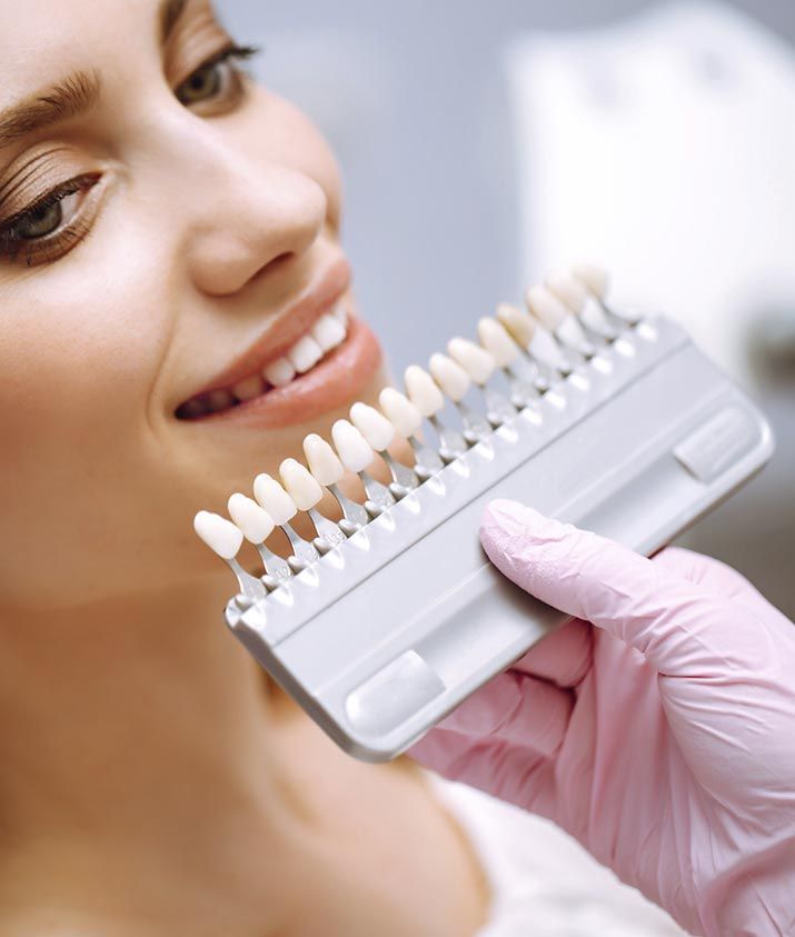 Una mujer se está blanqueando los dientes con un dentista.