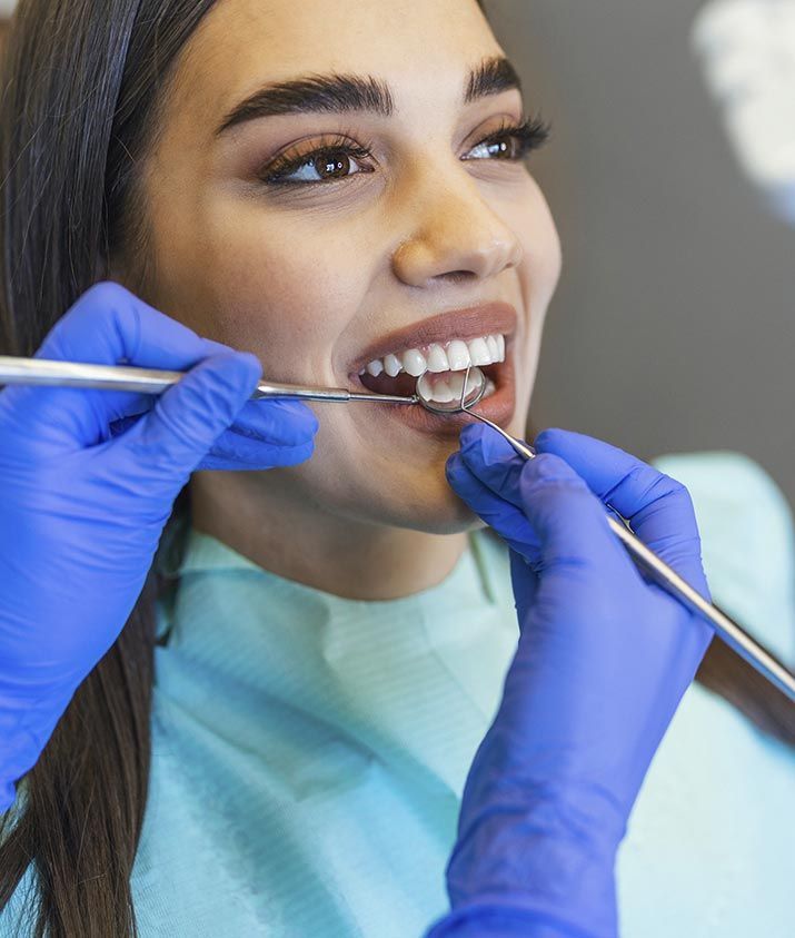 Una mujer está siendo examinada por un dentista.