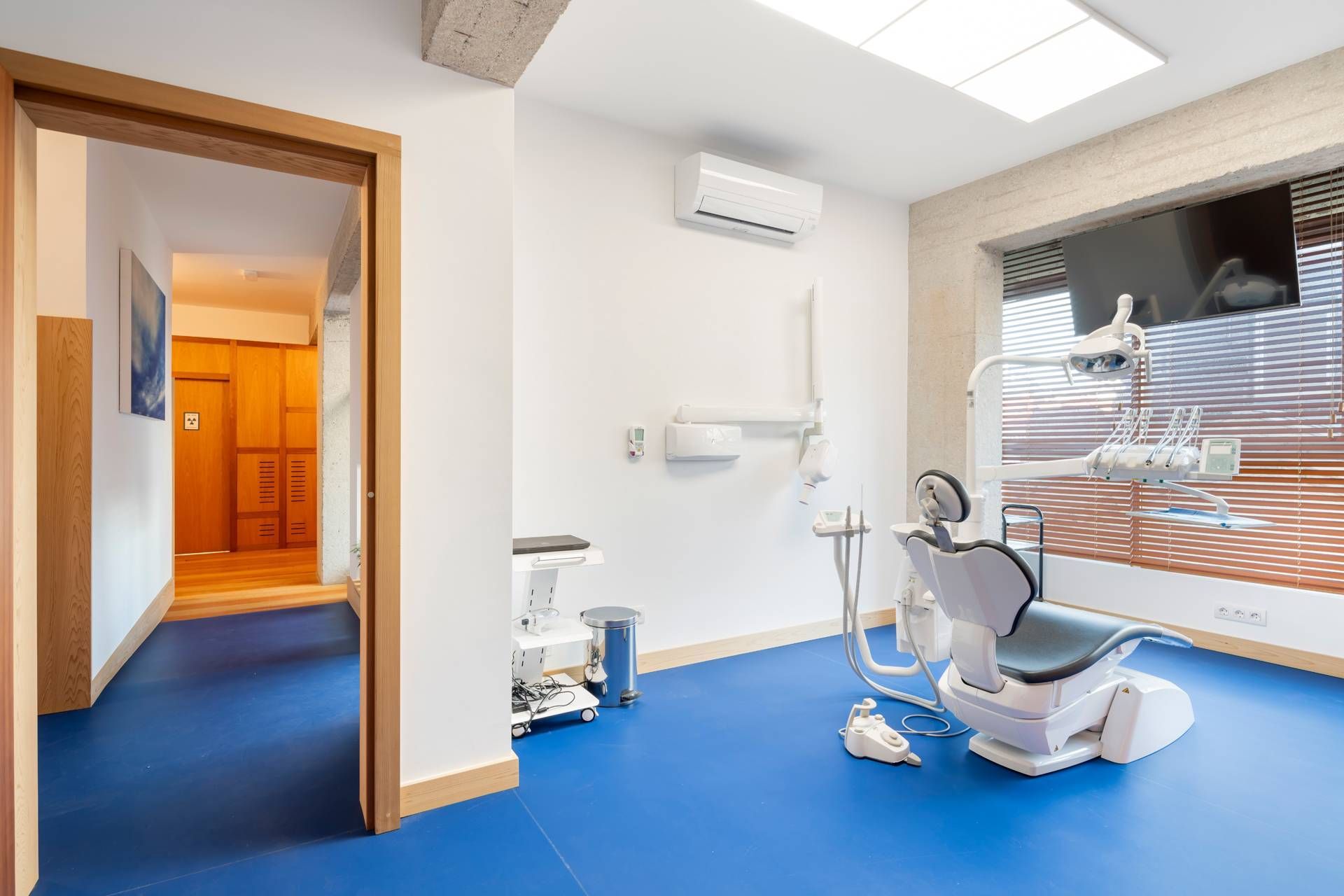 Un consultorio dental con sillas azules y un sofá blanco.