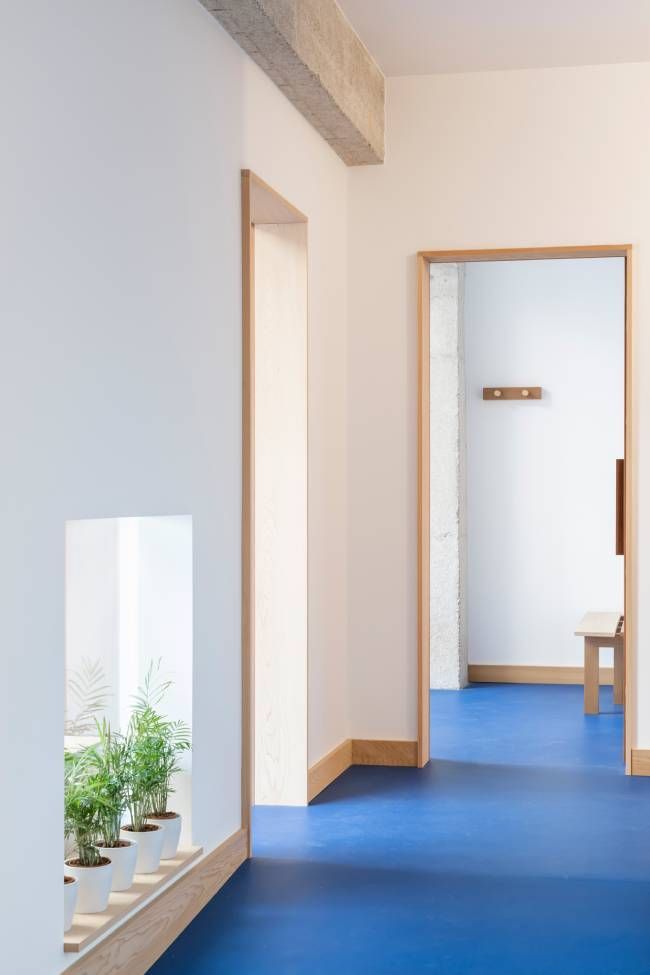Un pasillo con suelos azules y paredes blancas.