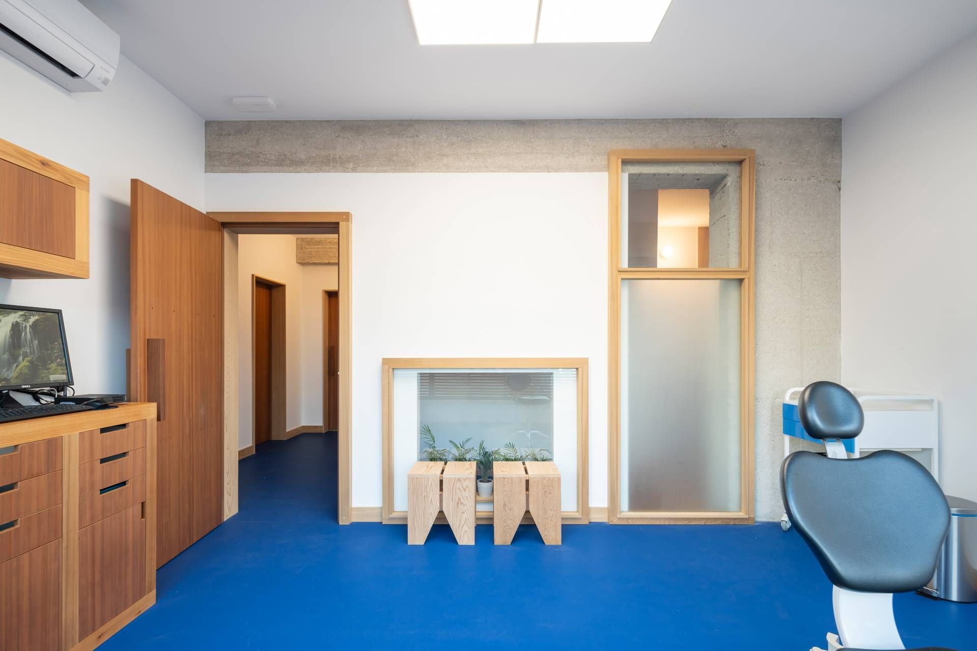 Un consultorio dental con piso azul y un sillón dental.