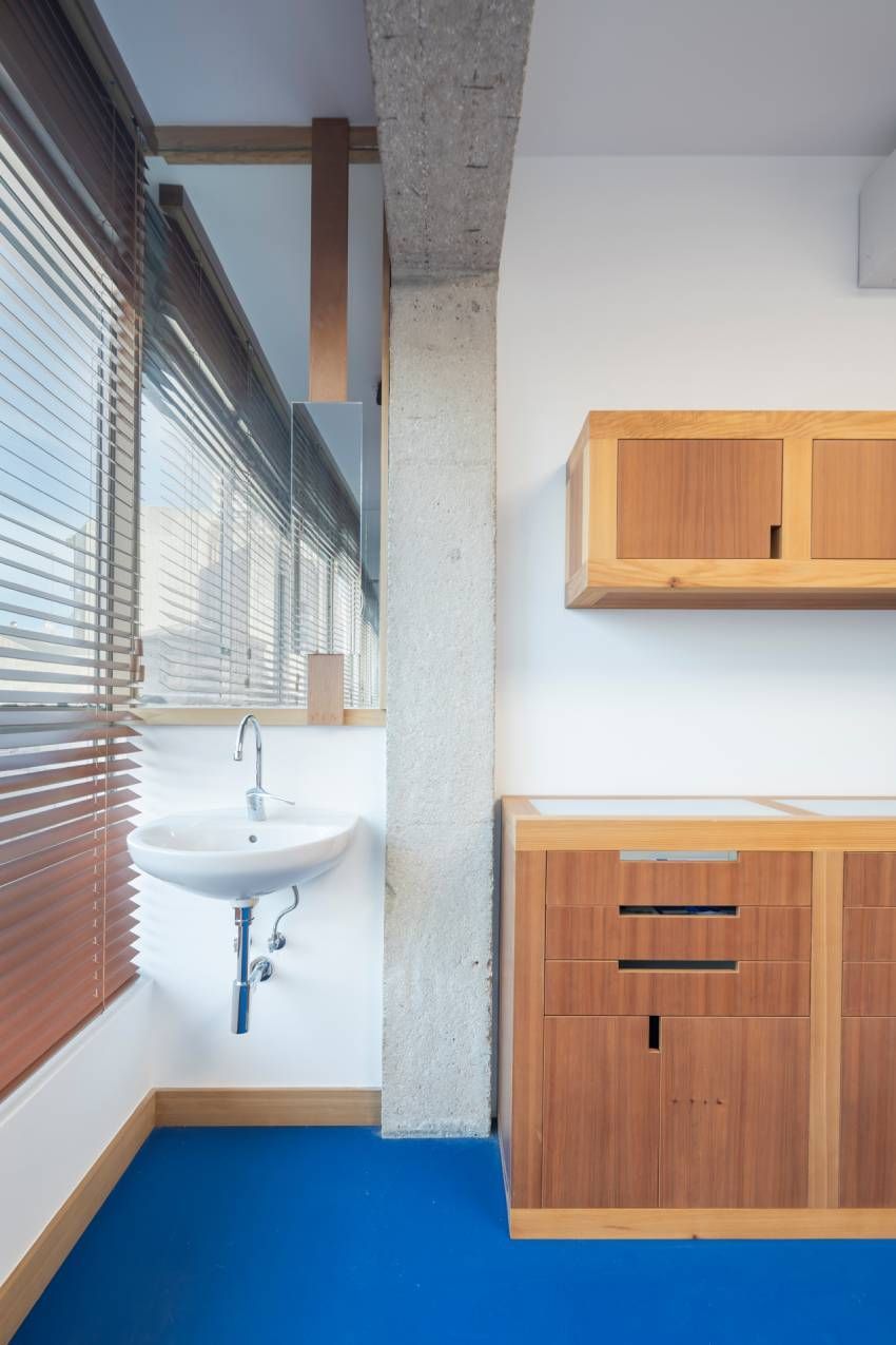 Un baño con lavabo, armarios y suelo azul.