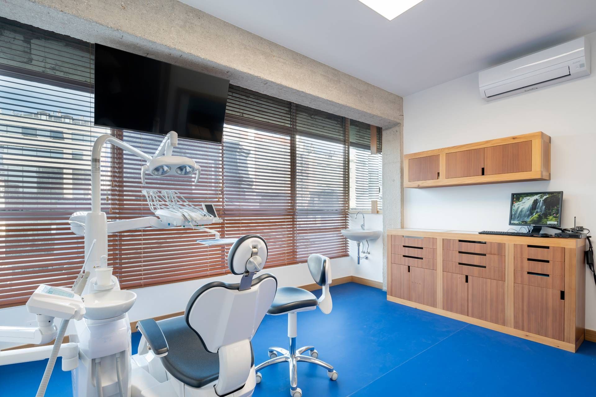 Un consultorio dental con suelo azul y un sillón dental.