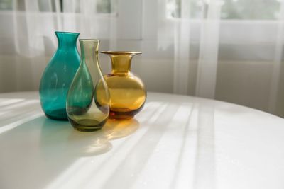 Una fila de cinturones de diferentes colores están alineados en un estante de una tienda.