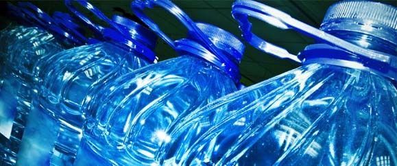 Un montón de botellas de plástico azules están apiladas una encima de otra.