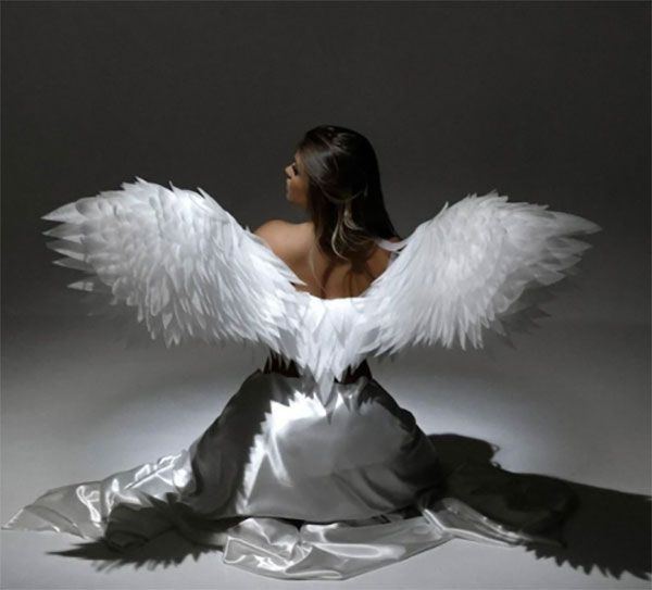 Una mujer con un vestido blanco y alas de ángel blancas.