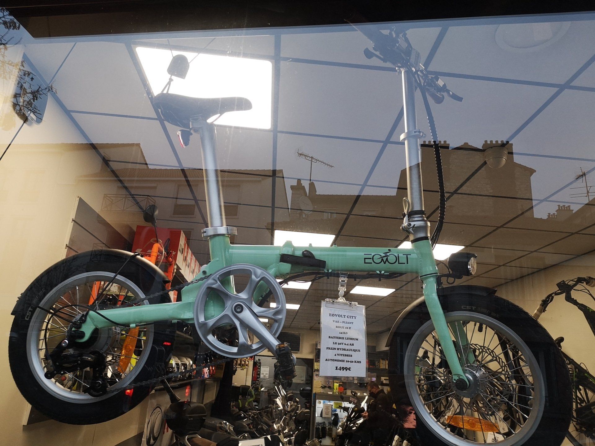 Un vélo électrique de couleur verte exposé dans une vitrine