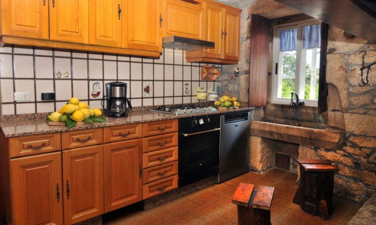 Una cocina con gabinetes de madera y electrodomésticos de acero inoxidable.