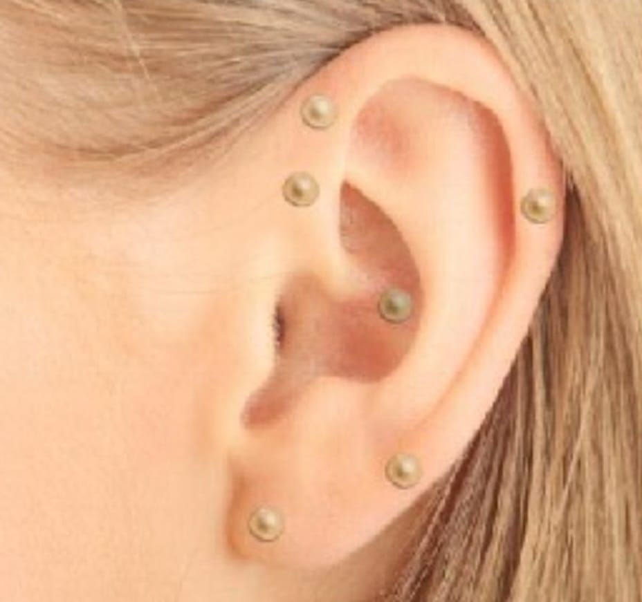 Un generador de flujo de iones Tesla Med de color blanco reposa sobre un pedestal con un anillo blanco brillante de fondo oscuro.