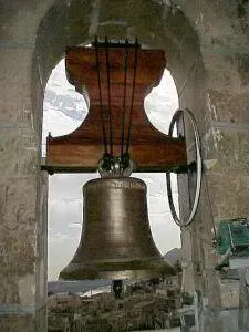 Una gran campana cuelga del techo de una iglesia.